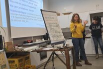 Person steht neben Flipchart in einem Seminarraum