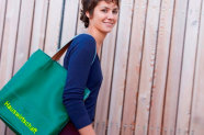 Junge Frau trägt Tasche mit Aufschrift "Hauswirtschaft" unter dem Arm