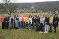 Personen stehen auf einer Wiese