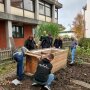 Landwirtschaftstudierende helfen das Hochbeet aufzustellen.