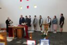 8 Personen stehen im Kirchenraum hintereinander. 