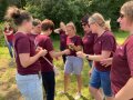 Eine Studierende hat die Heilpflanze Odermenig in der Hand, weitere sieben bestaunen sie