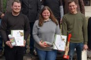 Drei Personen stehen nebeneinander und halten Urkunde