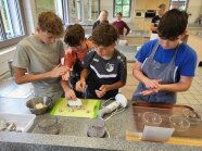 Schüler stehen in Küche und arbeiten mit Teig