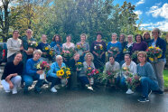 20 neue Studierende halten ihre selbst gebundenen Blumensträuße in den Händen