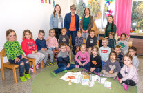 Gruppenbild von Kindern und Erwachsenen in einem Raum