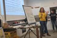 Person steht neben Flipchart in einem Seminarraum