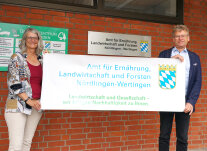 2 Personen halten ein Banner