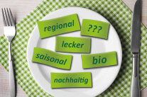 Grüne Zettel mit den Worten regional lecker saisonal bio nachhaltig auf Tischgedeck