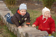 Zwei Kinder spielen an einer Holzbrücke